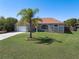 Beautiful single-story home with a lush green lawn, palm tree, and mature landscaping at 1112 View Pointe Cir, Lake Wales, FL 33853