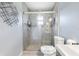Bathroom with tiled walk-in shower with glass door, tiled floors, and light-colored walls at 3548 Galloway Oaks Ct, Lakeland, FL 33810