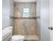 Bathroom with a modern commode and a shower stall featuring decorative tile at 3548 Galloway Oaks Ct, Lakeland, FL 33810