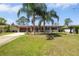 Charming single-story home featuring solar panels, a well-manicured lawn, and inviting curb appeal with tropical landscaping at 1062 Mayflower Ave, Deltona, FL 32725