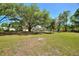 A large backyard features mature trees and a well-maintained lawn at 4609 Creek Meadow Trl, Lakeland, FL 33810