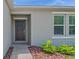 Close-up of the home's entry featuring decorative landscaping and a modern black front door at 140 Jones Fish Camp Rd, Edgewater, FL 32141