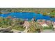 Beautiful aerial view of home on a large lake with mature landscaping and well manicured lawn at 10837 Versailles Blvd, Clermont, FL 34711