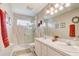 Modern bathroom with double sinks, a glass-enclosed shower, and a vanity mirror at 10837 Versailles Blvd, Clermont, FL 34711