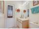 Bright bathroom featuring a single sink vanity, mirror, and exterior door with privacy curtain at 10837 Versailles Blvd, Clermont, FL 34711