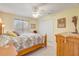 Comfortable bedroom features a queen bed, ceiling fan, and a large dresser at 10837 Versailles Blvd, Clermont, FL 34711