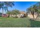 Charming single-story home featuring a well-manicured lawn and mature palm trees at 10837 Versailles Blvd, Clermont, FL 34711