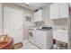 Well-equipped laundry room with washer, dryer, sink, and storage cabinets at 10837 Versailles Blvd, Clermont, FL 34711