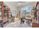 Well-lit office space with a large window, desk, sofa, and built-in bookshelves, creating an ideal workspace at 10837 Versailles Blvd, Clermont, FL 34711