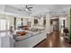 Open-concept living room with hardwood floors, ceiling fan, and seamless flow to kitchen and dining at 3688 Hurlbut Cir, Lake Wales, FL 33898