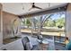 Relaxing screened patio with a ceiling fan, string lights, and wicker furniture overlooks a spacious yard with trees at 3688 Hurlbut Cir, Lake Wales, FL 33898
