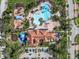 Aerial view of community amenities, including a pool, splashpad, playground, and clubhouse surrounded by lush landscaping at 4002 Bougainvillea Pl, Kissimmee, FL 34746