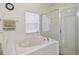 Bathroom features a white soaking tub with tile surround and separate glass shower at 4002 Bougainvillea Pl, Kissimmee, FL 34746