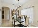 Bright dining room with tile floors, a modern chandelier, and a glass-top table at 4002 Bougainvillea Pl, Kissimmee, FL 34746