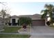 Charming single-story home with lush landscaping, brick driveway, and a two-car garage at 4002 Bougainvillea Pl, Kissimmee, FL 34746