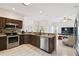 Open kitchen featuring stainless steel appliances, granite countertops, and seamless flow to the living area at 4002 Bougainvillea Pl, Kissimmee, FL 34746