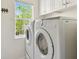 Bright laundry room equipped with modern washer and dryer units and ample natural light from the window at 4002 Bougainvillea Pl, Kissimmee, FL 34746