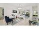 Stylish living room featuring a white sofa, glass coffee table, and sliding glass doors at 4002 Bougainvillea Pl, Kissimmee, FL 34746