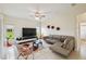 Bright living room with tile floors, stylish seating, and a large TV for entertainment at 4002 Bougainvillea Pl, Kissimmee, FL 34746
