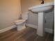 Clean bathroom featuring tiled floors, a modern toilet, and pedestal sink at 16906 Cedar Valley Cir, Clermont, FL 34711