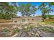 A view of the house's backyard with lush trees, a spacious lawn and a full privacy fence at 2415 Sutton Rd, Lakeland, FL 33810
