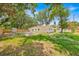 Lush green backyard showing a storage shed, a fence, an expansive lawn, and mature trees at 2415 Sutton Rd, Lakeland, FL 33810