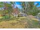 Charming home with lush green lawn, mature trees, and a fenced yard at 2415 Sutton Rd, Lakeland, FL 33810