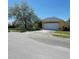 Charming single-story home featuring a two-car garage, well-manicured lawn and mature tree at 447 Wildflower Rd, Davenport, FL 33837