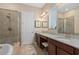 Bright bathroom features double sinks with granite counters, soaking tub and a glass enclosed shower at 9170 Tavistock Lakes Blvd, Orlando, FL 32827