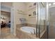 View of the bathtub, shower and door into the bedroom in this primary bathroom at 9170 Tavistock Lakes Blvd, Orlando, FL 32827