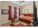 Comfortable bedroom with wood-look floors, ceiling fan and ample natural light from the large window at 9170 Tavistock Lakes Blvd, Orlando, FL 32827