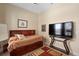 This is a nice bedroom featuring wood look floors, a large bed and a television at 9170 Tavistock Lakes Blvd, Orlando, FL 32827