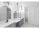 Bright bathroom with dual sinks, blue vanities, a tiled floor, and decorative shelving at 1508 Leighton Ave, Lakeland, FL 33803