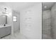 Bright bathroom featuring marble-tiled walls, a glass shower, and built-in decorative shelving at 1508 Leighton Ave, Lakeland, FL 33803
