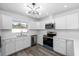 Modern kitchen with white cabinets, stainless steel appliances, and quartz countertops at 1508 Leighton Ave, Lakeland, FL 33803