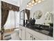 Bathroom featuring double sinks with white cabinets, a dark countertop, and decorative fixtures at 252 Bayou Bend Rd, Groveland, FL 34736