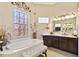 Bright bathroom features a soaking tub and a patterned glass block window at 252 Bayou Bend Rd, Groveland, FL 34736