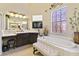 Elegant bathroom featuring a soaking tub and vanity area at 252 Bayou Bend Rd, Groveland, FL 34736