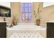 Bright bathroom features a soaking tub, large window, and neutral color palette creating a relaxing atmosphere at 252 Bayou Bend Rd, Groveland, FL 34736