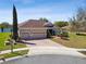 Charming home featuring a three-car garage, brick driveway, and mature landscaping in a cul-de-sac at 252 Bayou Bend Rd, Groveland, FL 34736