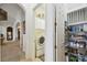 Bright hallway featuring a laundry room with stacked washer/dryer and a walk-in pantry with shelving at 252 Bayou Bend Rd, Groveland, FL 34736