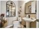 Charming powder room featuring pedestal sink, decorative mirror, and stylish accents for a refined touch at 252 Bayou Bend Rd, Groveland, FL 34736