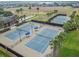 Aerial view of blue community tennis courts with palm tree landscaping at 252 Bayou Bend Rd, Groveland, FL 34736