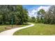 Outdoor walking path amid green landscaping with large trees, a grassy field, and a green mile marker post at 4771 Golden Knight Blvd, Kissimmee, FL 34746