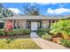 Inviting front entrance of the home features a double door entry framed with mature trees and manicured shrubbery at 282 Lake Griffin Cir, Casselberry, FL 32707