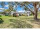 A lush lawn and mature trees enhance the curb appeal of this brick home at 282 Lake Griffin Cir, Casselberry, FL 32707