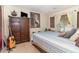 Cozy bedroom with a striped bedspread, wooden dresser, and unique wall art at 820 Rio Ala Mano Dr, Altamonte Springs, FL 32714