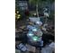 Illuminated rock water feature surrounded by garden landscaping creates a peaceful outdoor ambiance at 820 Rio Ala Mano Dr, Altamonte Springs, FL 32714