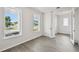 A bright and spacious room featuring stylish flooring, with 2 windows and a view of the homes across the street at 3083 Voyager Ave, St Cloud, FL 34771