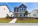 Charming two-story home with blue and gray accents, a welcoming front porch and professionally landscaped front yard at 3083 Voyager Ave, St Cloud, FL 34771